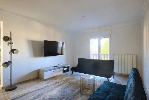 un salon avec un canapé et une télévision à écran plat dans l'établissement Maison 8 pers et 2 lits bébés, à Metz