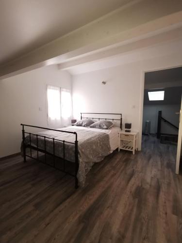 une chambre avec un lit et un parquet dans l'établissement logement 1Chambre et 1 clic clac, à Castets