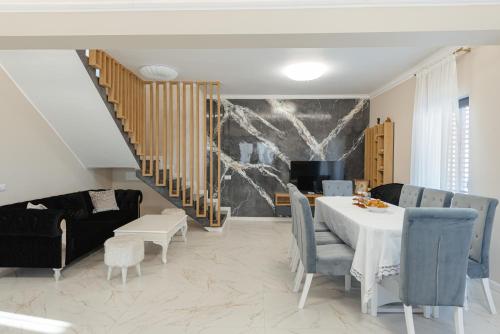a dining room with a table and chairs and a staircase at Casa Bella Vlădeasa in Săcuieu