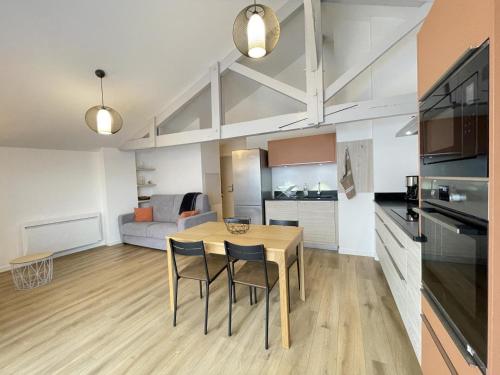 une cuisine et un salon avec une table et des chaises dans l'établissement Toutou, à Anglet