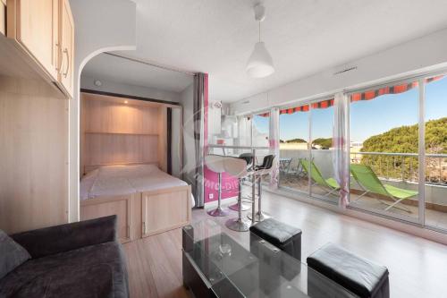 un salon avec un canapé et une table en verre dans l'établissement AS9557 - Studio vue sur la mer avec parking privé proche centre ville, au Grau-du-Roi