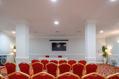 a room with a bunch of chairs and a tv at Sachas Hotel Manchester in Manchester