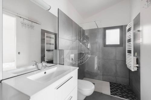une salle de bain blanche avec un lavabo et des toilettes dans l'établissement AS13871 - P2 en duplex au Centre Ville avec magnifique vue, au Grau-du-Roi