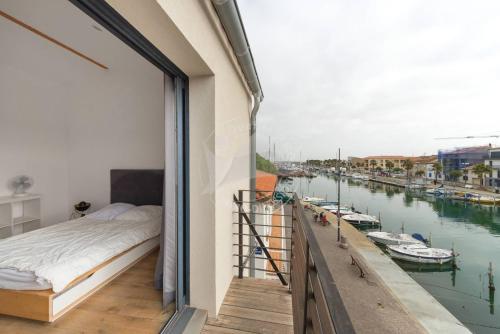 - une chambre avec un lit et une vue sur le port de plaisance dans l'établissement AS13871 - P2 en duplex au Centre Ville avec magnifique vue, au Grau-du-Roi