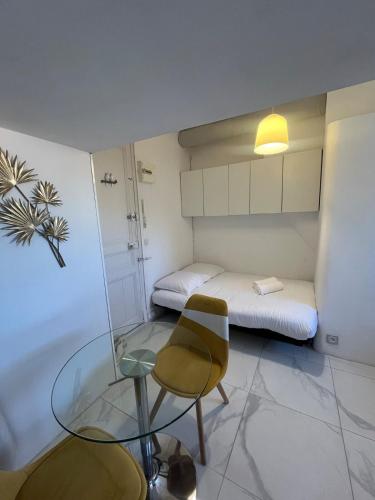 Cette petite chambre comprend une table en verre et un lit. dans l'établissement Gounod - Studio cosy dans le centre de Nice, à Nice