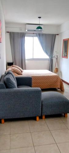 a bedroom with a bed and a couch and a window at Monoambiente M y L in La Plata