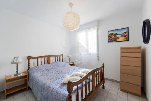 une chambre avec un lit, une commode et une fenêtre dans l'établissement AS16245 - P2 Belle vue lac avec parking privé, au Grau-du-Roi