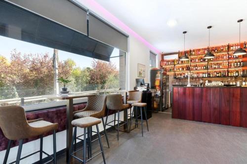 a bar with a bunch of stools in a room at Olhos d' Água in Alcanena