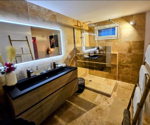 une salle de bain avec un lavabo et un grand miroir dans l'établissement Love Room Provençale studio, au Castellet