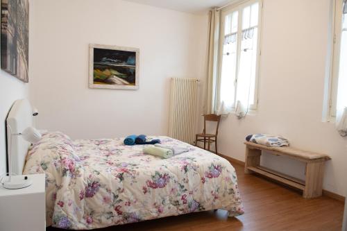 a bedroom with a bed and a table and windows at Historic center Teatro Regio appartamento Luca in Parma
