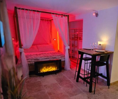 Cette chambre rouge comprend un lit et une cheminée. dans l'établissement Love Room Provençale studio, au Castellet