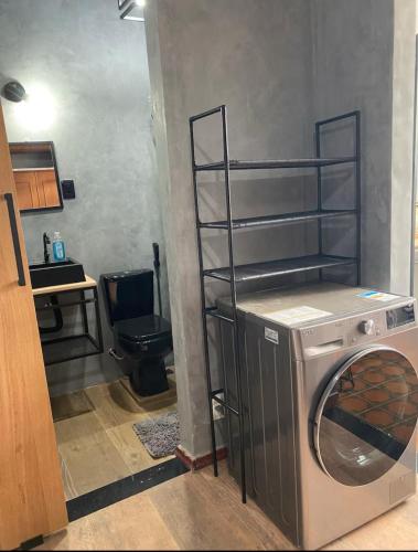 a laundry room with a washing machine and a shelf at Paqueta home in Rio de Janeiro