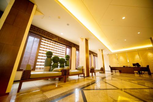 a lobby with couches and a piano in a building at Hotel Africana in Kampala