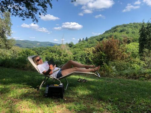 a woman sitting in a chair with a book at Les Cavaleries in Nonards