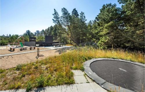 a backyard with a swimming pool and a playground at Nice Home In Blåvand With Kitchen in Blåvand