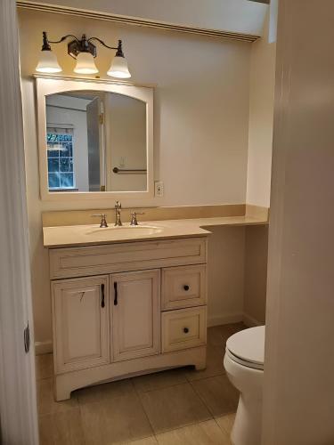 a bathroom with a sink and a mirror and a toilet at Olive Startup House in Palo Alto
