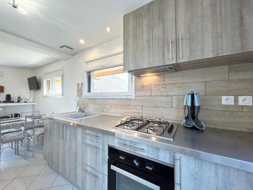 une cuisine avec une cuisinière et un évier dans l'établissement Le Chavanna - Terrasse Parking - CLG Savoie, à Saint-Pierre-dʼAlbigny