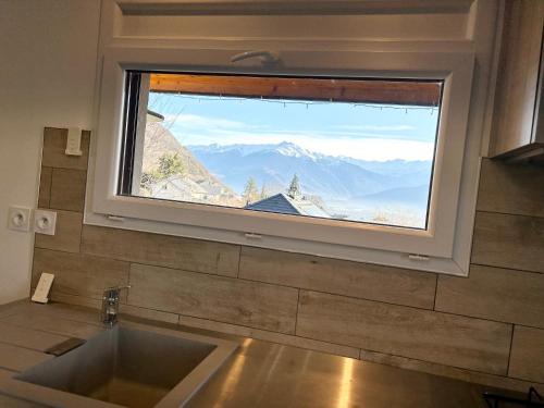 a window above a sink with a view of mountains at Le Chavanna - Terrasse Parking - CLG Savoie in Saint-Pierre-dʼAlbigny