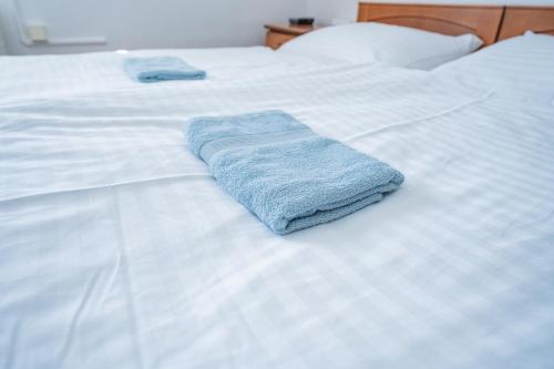 a blue towel sitting on top of a white bed at Penzion Zuzana in Staré Splavy