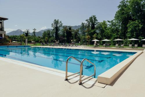a large blue swimming pool with chairs and umbrellas at Grand Hotel Telese in Telese