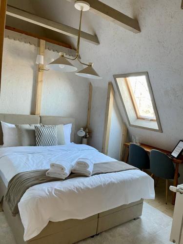 a bedroom with a large white bed with a window at Rustic Inn bed and breakfast in Budeşti