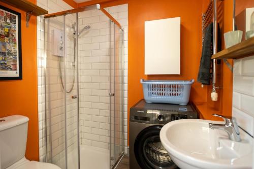 a bathroom with a washing machine and a sink at Family friendly, sleeps 5, 3 mins to beach in Deal