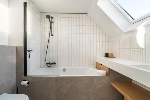 a bathroom with a bath tub and a sink at Stijlvol & lichtrijk Penthouse app met parking in Knokke-Heist