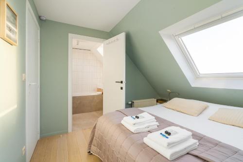 a bedroom with a bed with towels on it at Stijlvol & lichtrijk Penthouse app met parking in Knokke-Heist