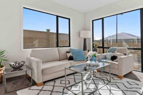 a living room with a couch and a table at Modern Beach Retreat 4 bedrooms in Papamoa