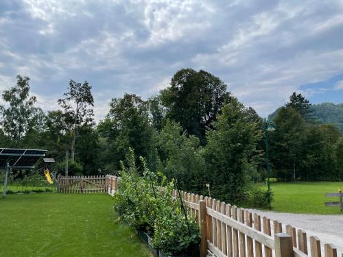 a wooden fence in front of a yard with trees at Wohnen am Almufer - Ferienwohnung Straßmair in Grünau im Almtal
