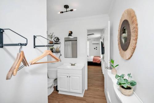 Un baño con lavabo, inodoro y espejo. en W. Cola Mini Pad -Tiny House, en West Columbia