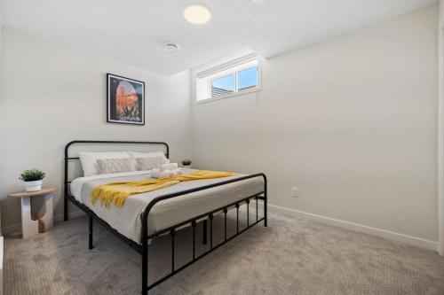 a bedroom with a bed with a yellow blanket on it at Private Lower Suite, Sleeps 4, Queen Bed, Netflix, Parking in Balzac