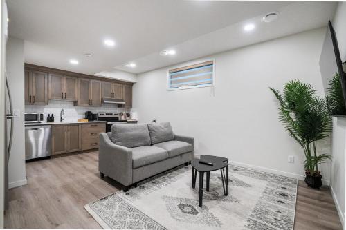 a living room with a couch and a kitchen at Private Lower Suite, Sleeps 4, Queen Bed, Netflix, Parking in Balzac
