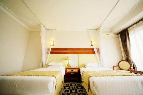 a room with two beds and a window at Hotel Africana in Kampala