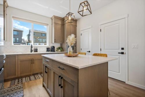 a kitchen with a large island and a window at 3 Bedroom Detached Home with Free Parking, Netflix, Free Banff Pass, King Size Bed & Portable AC in Balzac