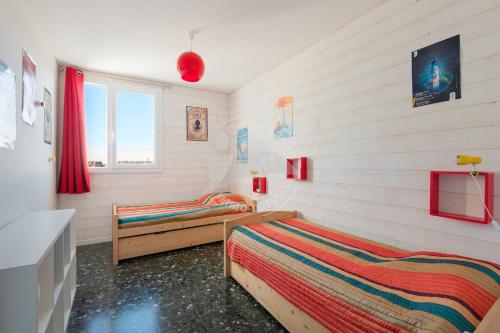 une chambre avec deux lits et une fenêtre dans l'établissement AS11148 - Appartement P3 Vue Mer, Centre Ville avec parking privé, au Grau-du-Roi