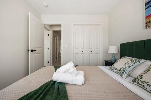 a bedroom with a large bed with towels on it at 3 Bedroom Detached Home with Free Parking, Netflix, Free Banff Pass, King Size Bed & Portable AC in Balzac