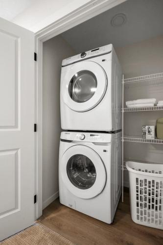 a washer and dryer in a laundry room at 3 Bedroom Detached Home with Free Parking, Netflix, Free Banff Pass, King Size Bed & Portable AC in Balzac