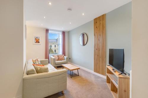 a living room with a couch and a tv at Earl Grey at The Tea Warehouse - North East Escapes in Alnwick