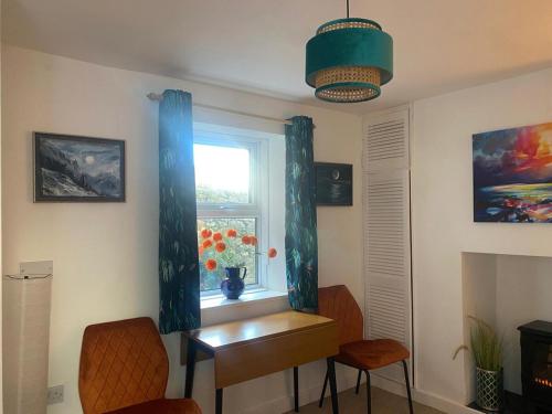 a room with a table and a window with blue curtains at Cosy Flat in Y Felinheli in Y Felinheli