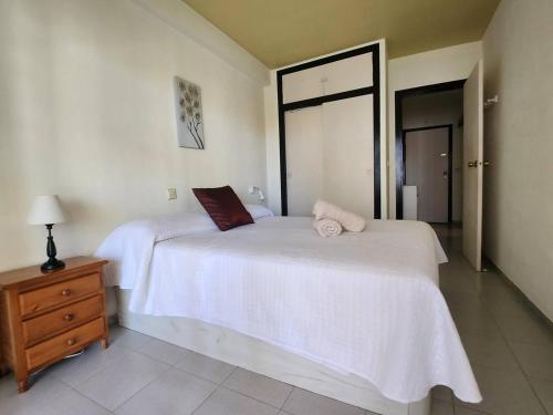 a bedroom with two beds with white sheets and a dresser at Amaika, cerca de playa, con aparcamiento y piscina in Calpe