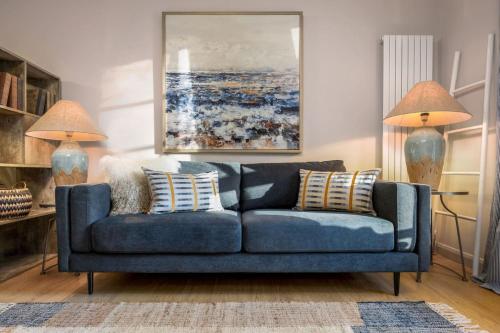 a blue couch in a living room with two lamps at The Mill Retreat in Stirling