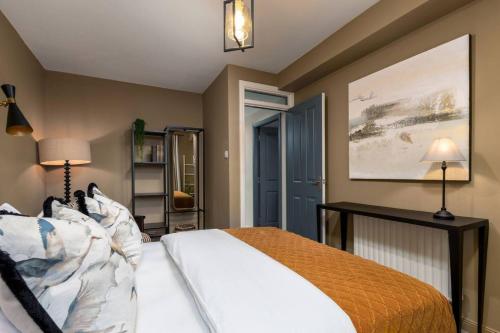 a bedroom with a bed and a painting on the wall at The Mill Retreat in Stirling