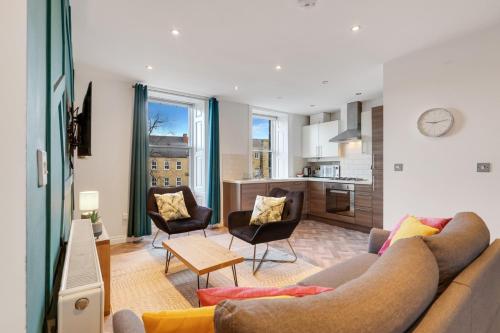 a living room with a couch and chairs and a kitchen at Darjeeling at The Tea Warehouse - North East Escapes in Alnwick