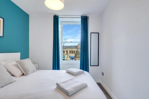 a bedroom with a white bed and a window at Darjeeling at The Tea Warehouse - North East Escapes in Alnwick