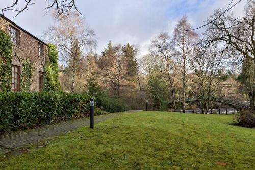 a grassy yard next to a brick building at The Mill Retreat in Stirling