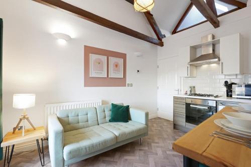 a living room with a couch and a kitchen at Ceylon - The Tea Warehouse in Alnwick