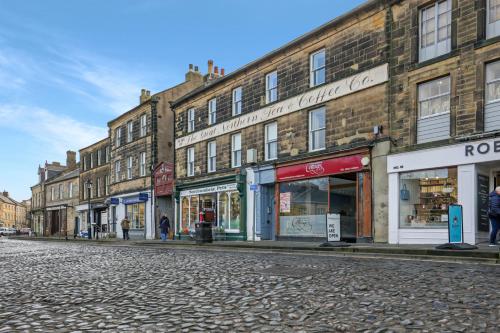 a cobblestone street with a group of buildings at Ceylon - The Tea Warehouse in Alnwick
