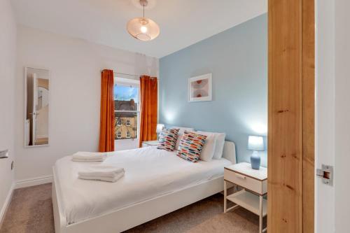 a bedroom with a white bed and a window at Chai at The Tea Warehouse - North East Escapes in Alnwick