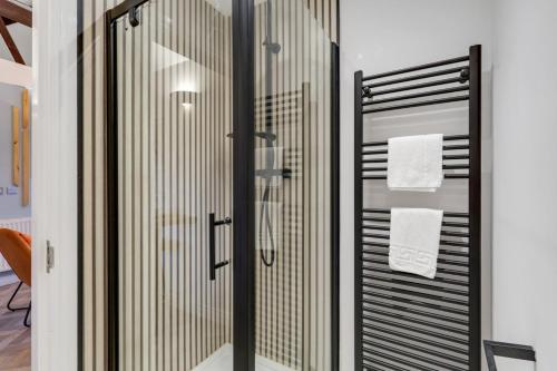 a bathroom with a glass shower with two towels at Chai at The Tea Warehouse - North East Escapes in Alnwick